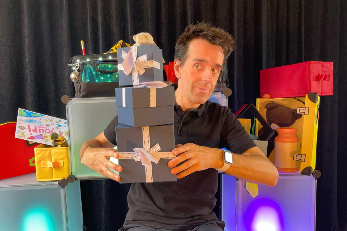 Monsieur Fred sur scène dans son décor imaginaire, présentant “Zouick, fouick, touick” à un jeune public émerveillé.