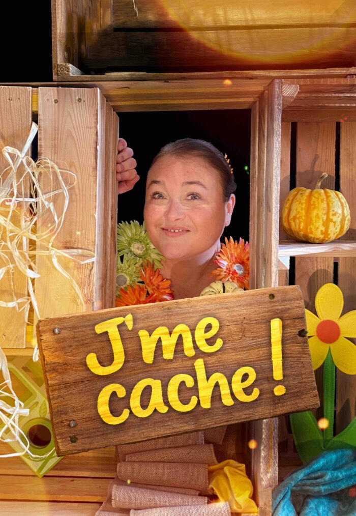 J'me cache ! Visuel d’affiche pour le spectacle de la comédienne conteuse Aurore, entouré de son décor en bois de ses fleurs et de sa pancarte de travers sur lequel est noté le titre du spectacle.